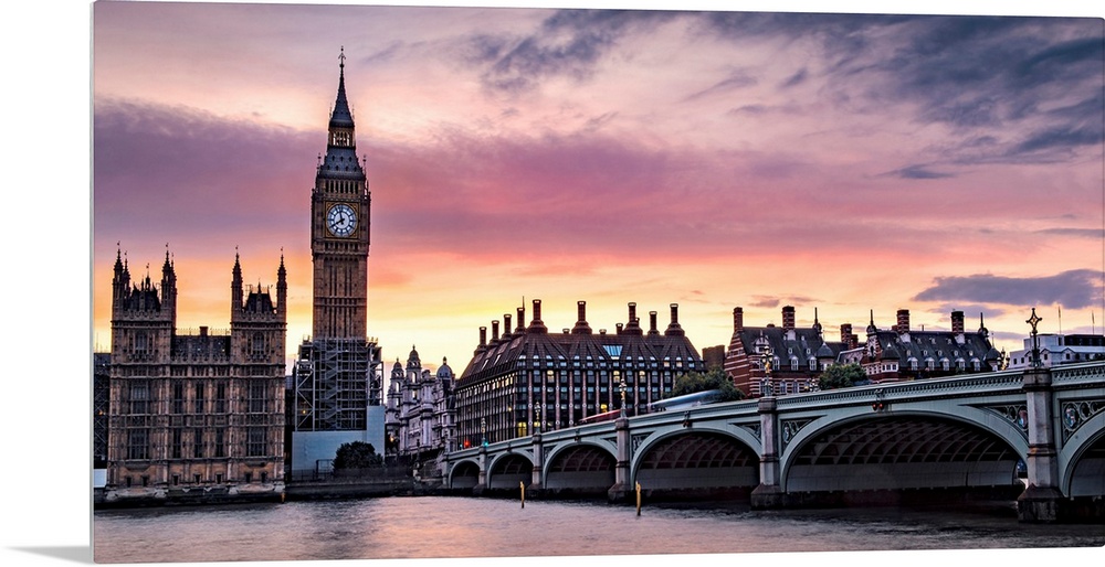 Panoramic photograph of Big Ben and the Westminster Bridge with a pink and purple sunset.