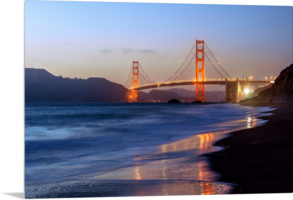 Twilight photograph of the Golden Gate Bridge taken from the shore.