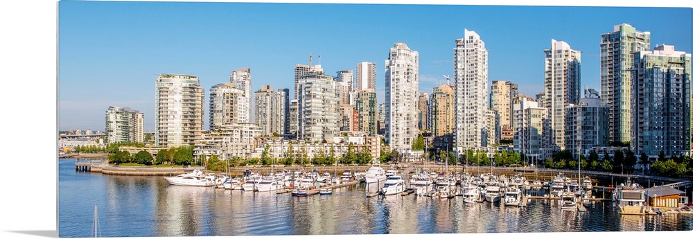 Panoramic photograph of part of the Vancouver, British Columbia skyline with False Creek Harbor and boats in the foreground.