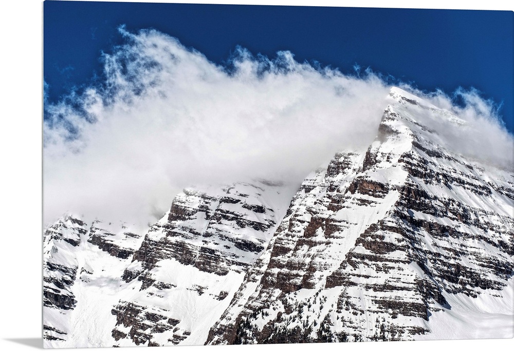 Wind-blown snow on the peaks of the Maroon Bells under a blue sky in Aspen, Colorado.