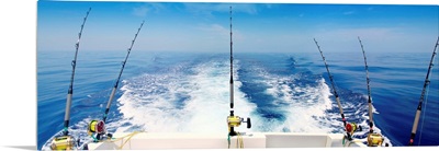 Fishing reels with cast lines off the back of a boat