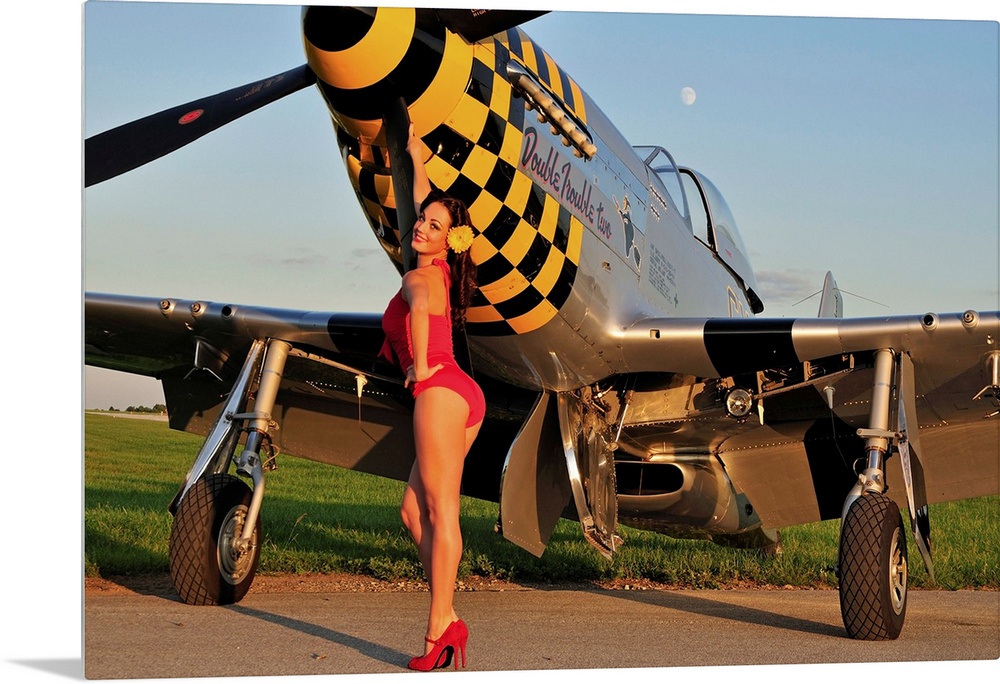 Sexy 1940's style pin-up girl posing with a P-51 Mustang fighter plane.