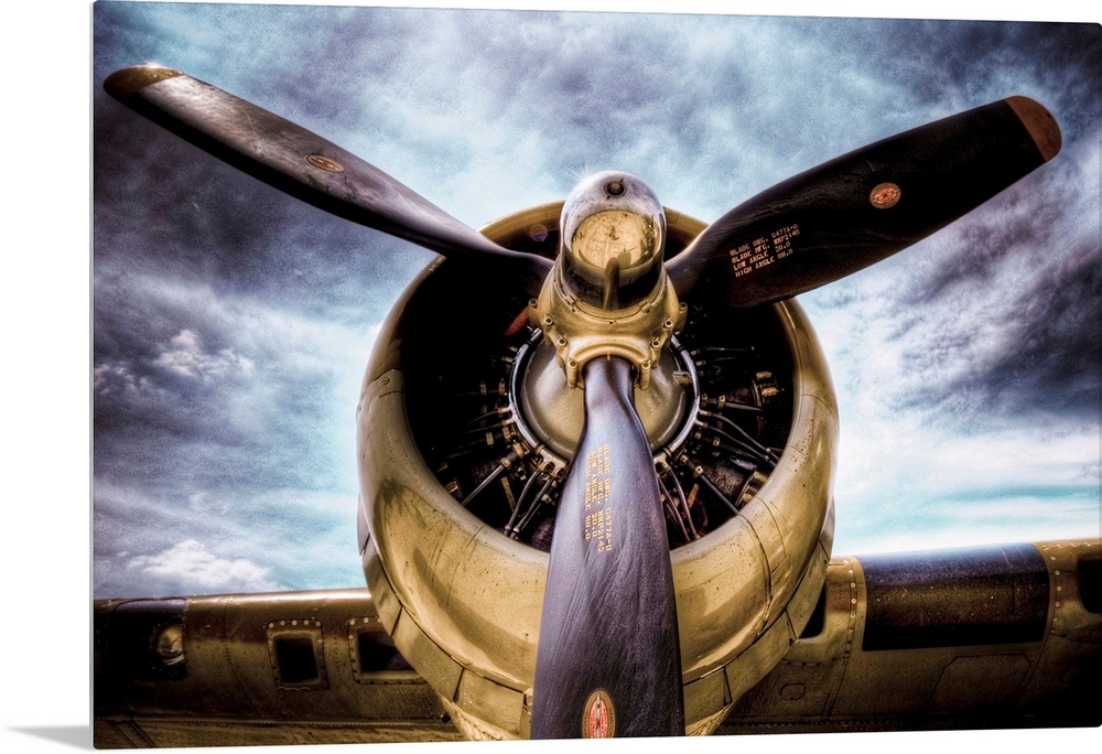 Front view photograph of vintage airplane with a dark cloudy sky in the background.