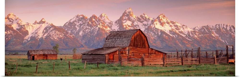 Panoramic photograph of a large barn on a farm in Grand Teton National Park in Wyoming. Located in the background are snow...