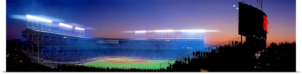 Panoramic photograph of a packed baseball stadium at night.