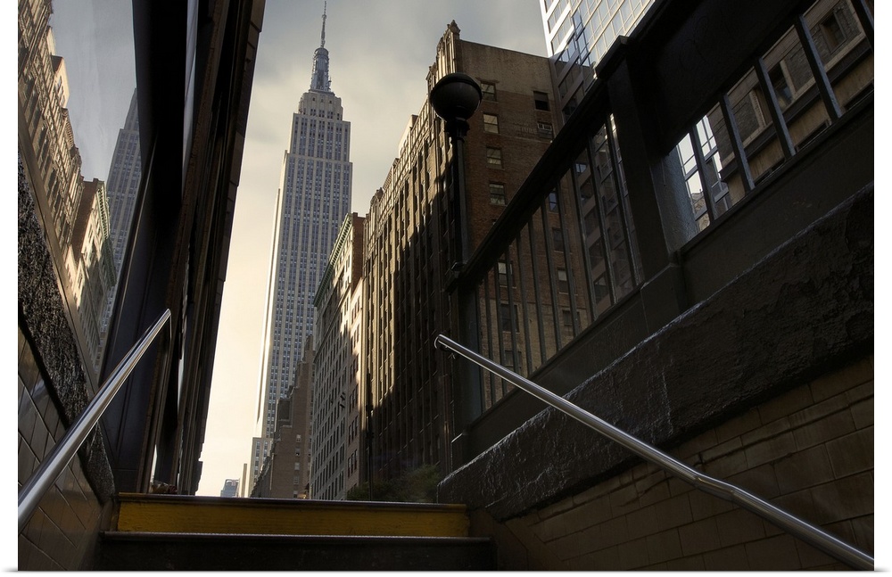 Photograph looking up towards the Empire State Building in NYC from the subway staircase.