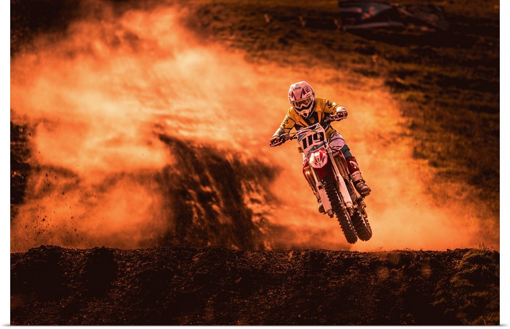 A photograph of a motocross rider caught in the air while riding a dirt track.