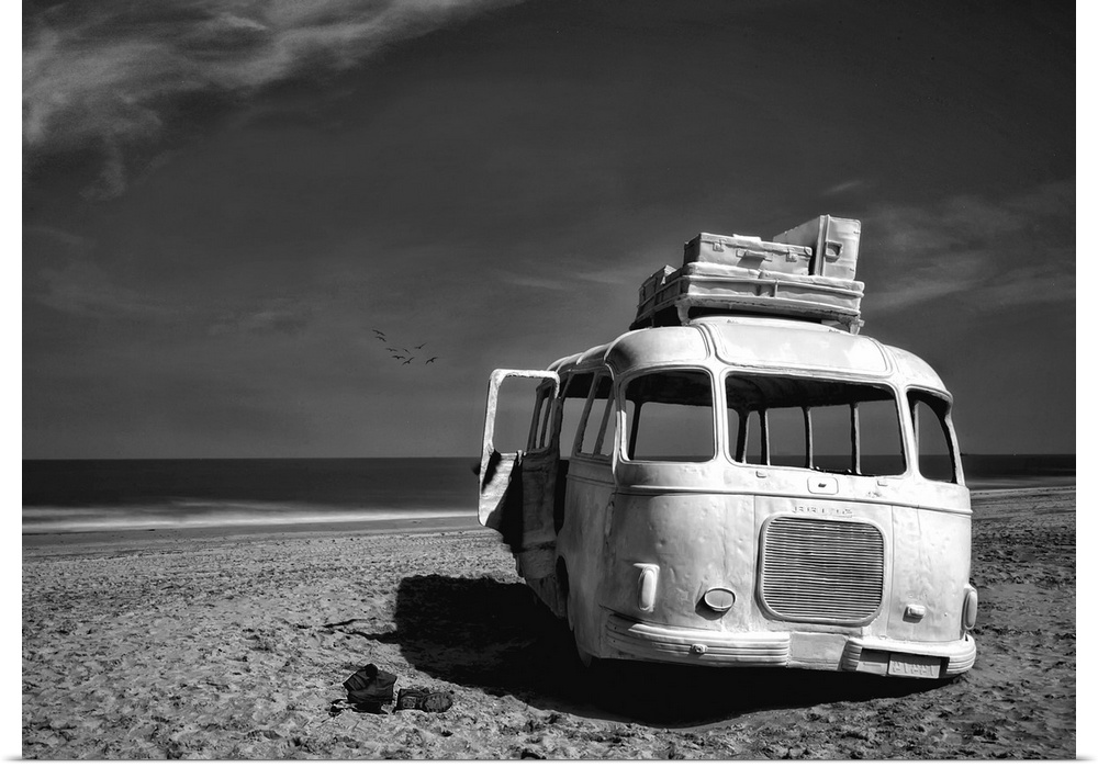 Black and white image of an abandoned bus with windows missing on a sandy beach in Belgium.