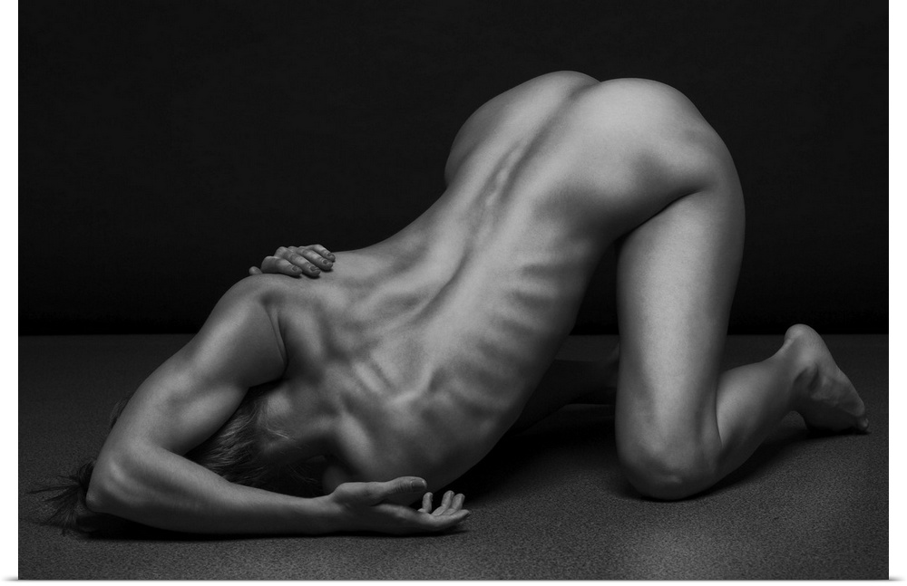 Black and white fine art photograph of a nude woman creating angles and shapes with her body.