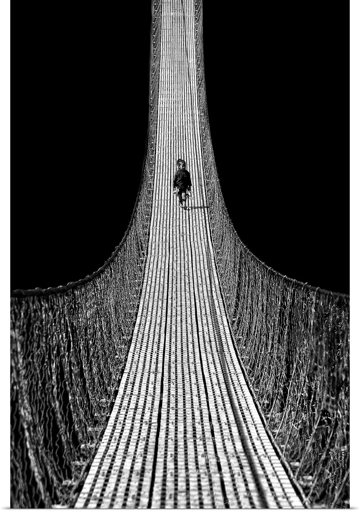 A child walks along a very long rope bridge.