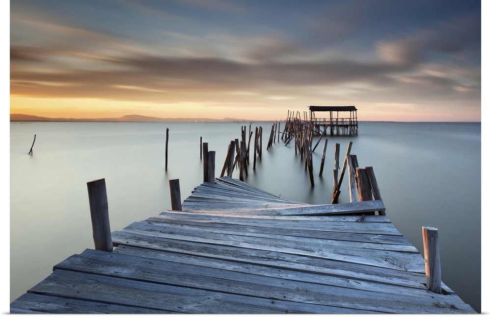 A broken wooden pier off the coast of Carrasqueira, Portugal, at sunset.