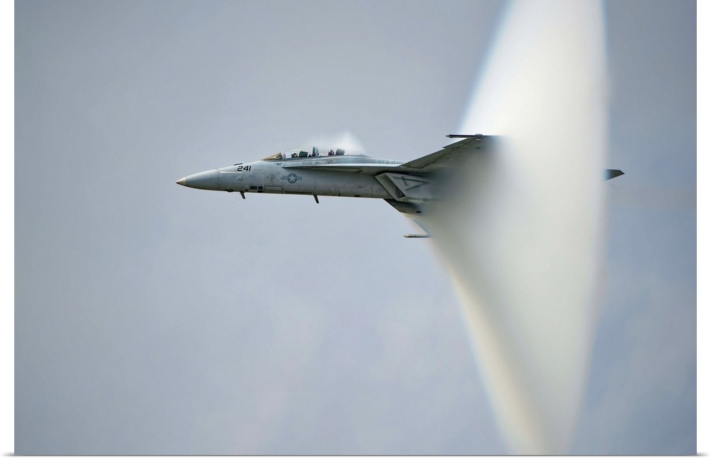 A F/A-18 Super Hornet forming a cone of air as it breaks the sound barrier.
