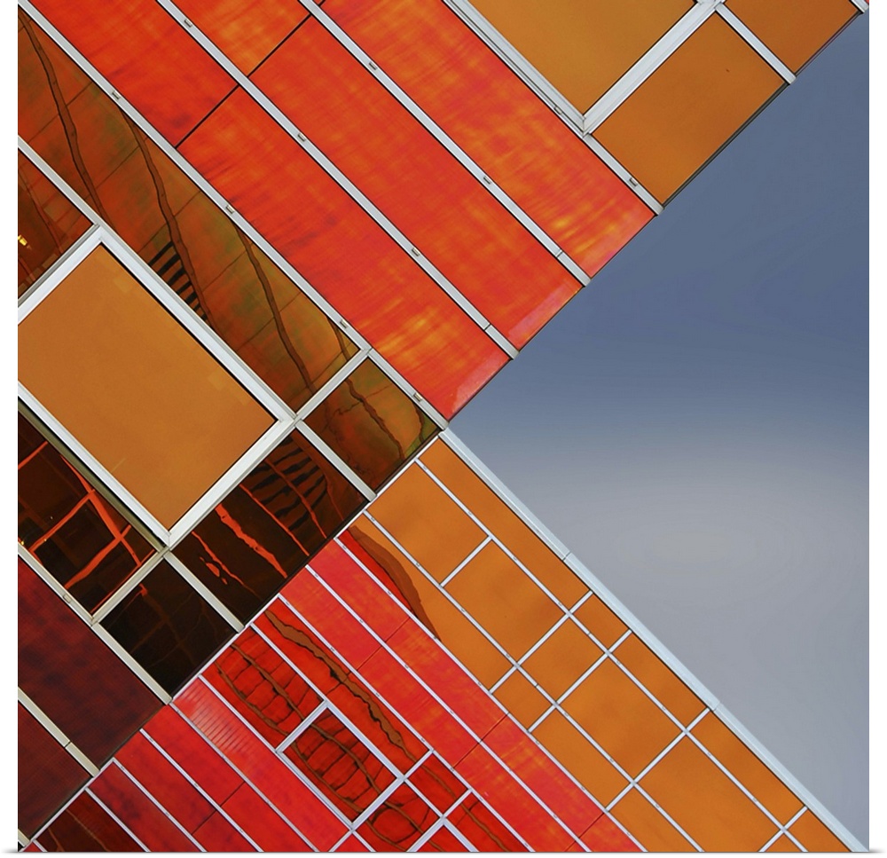 Orange glass panels on the facade of a building, with complex lines, creating an abstract image.