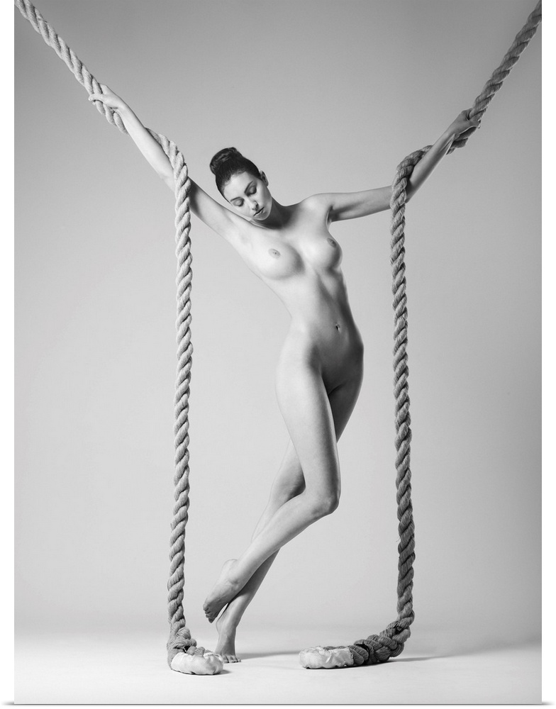 Black and white fine art photograph of a nude woman intertwined with two large ropes.
