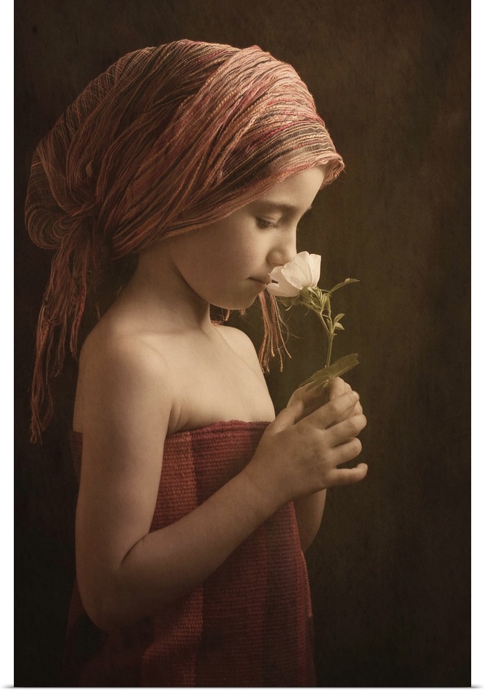 Portrait of a girl wearing robes smelling a flower.