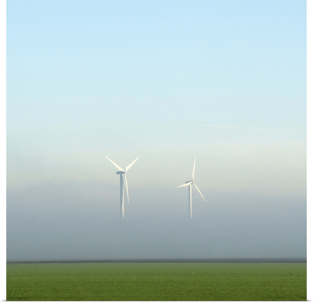 Two energy turbines appear to float in the air, their bases hidden in mist.