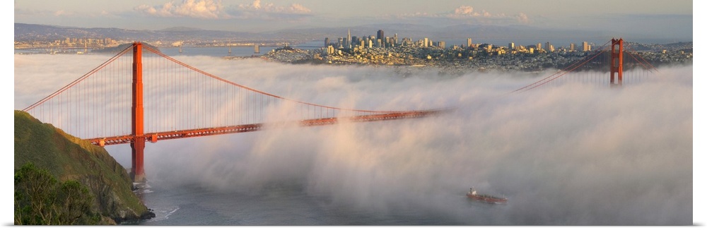 Panoramic photograph of the foggy Golden Gate Bridge in San Fransisco with the skyline in the background.