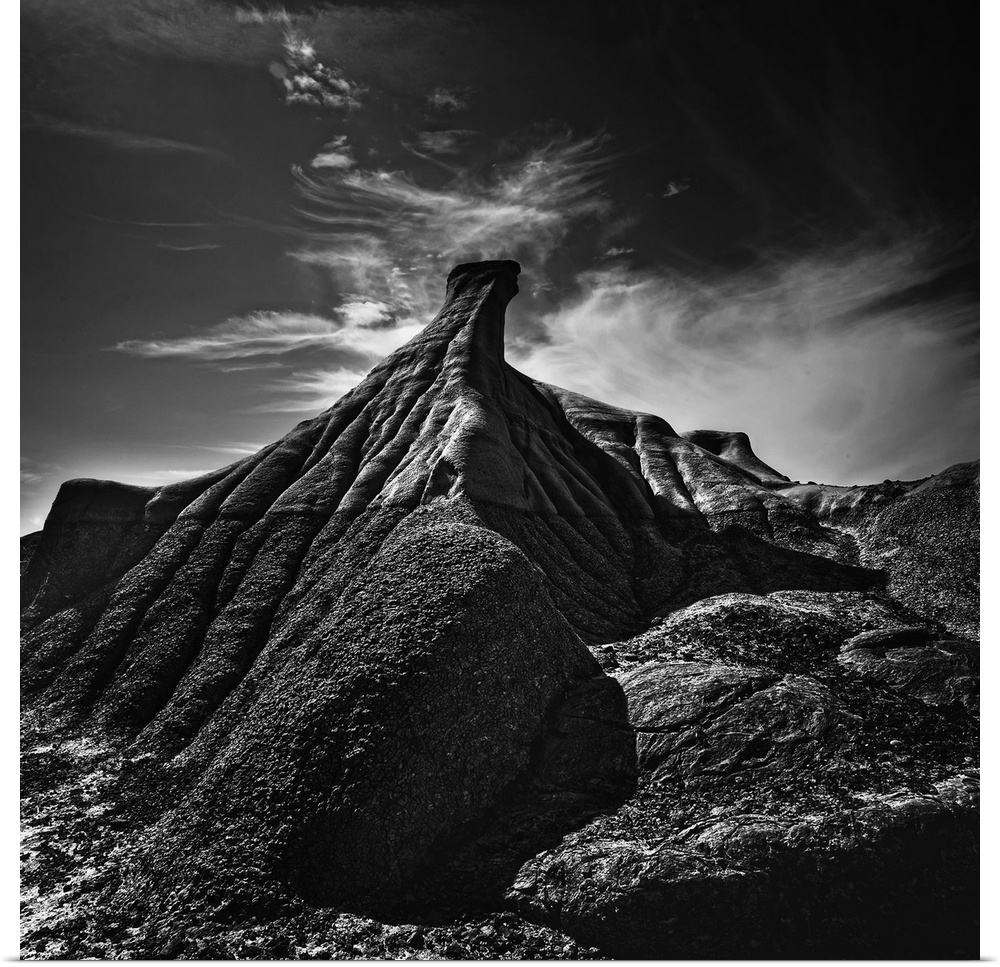 High contrast photograph of a rock formation in an arid desert landscape.