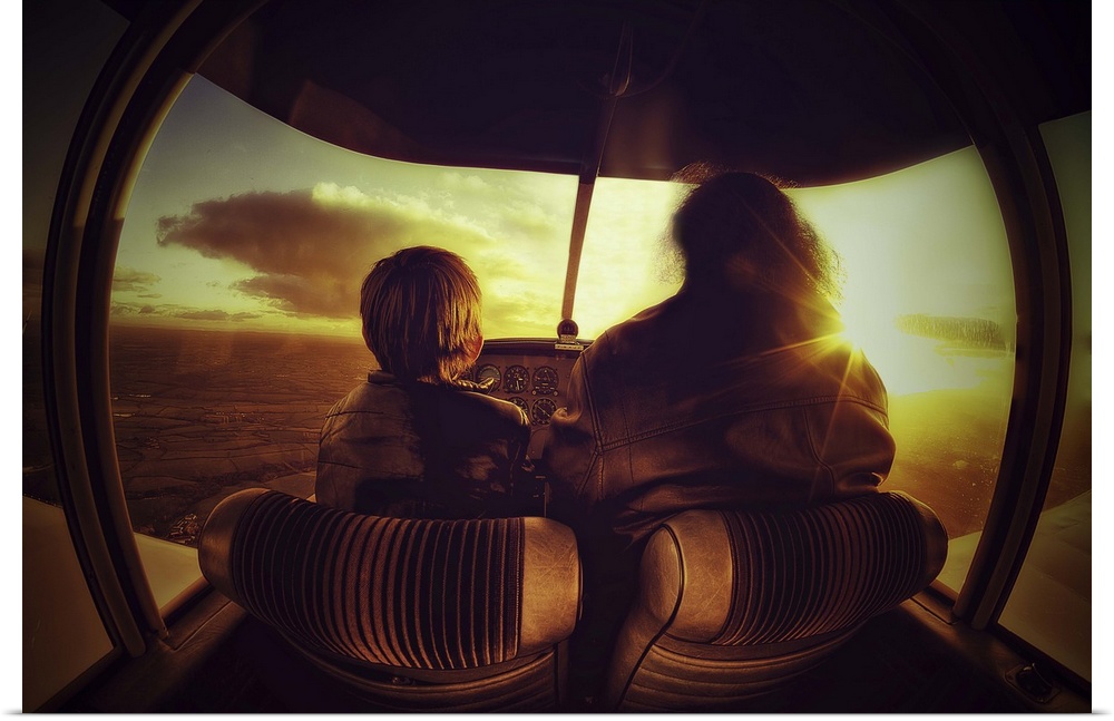 A young boy and an adult in the cockpit of a small plane.
