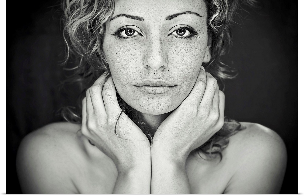 A black and white portrait of a woman with freckles all over her face.