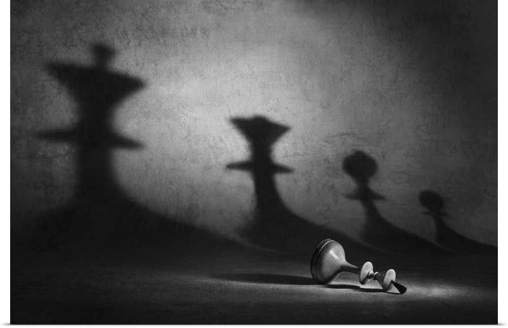A pawn laying on its side with shadows of other chess pieces looming over it.