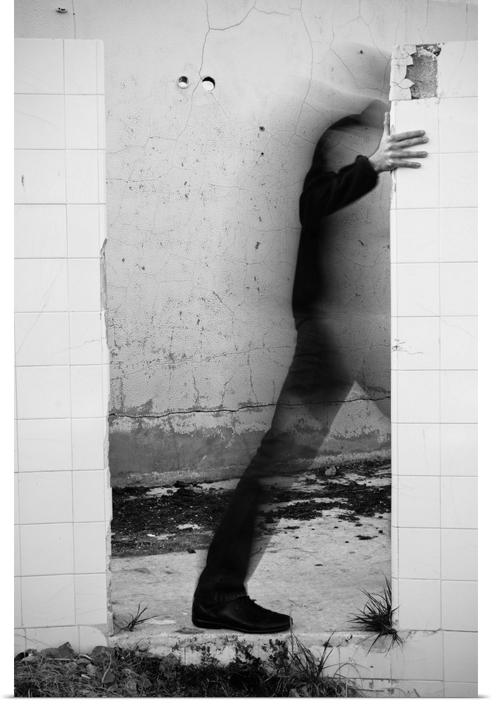 Conceptual photograph of a male figure stepping through a wall.