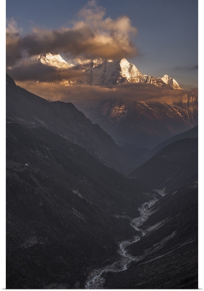 A dynamic photograph of a mountain range above a deep valley.