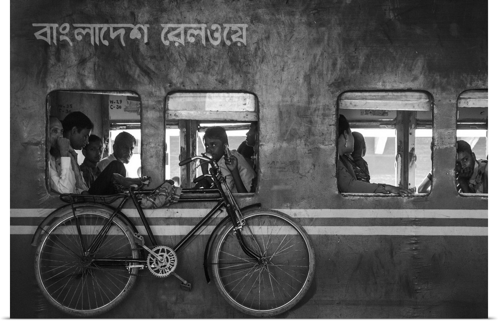 A train with people heading home and a bike hanging from the side, Bangladesh.