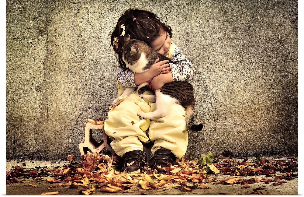 A portrait of a little girl sitting against a wall and holding a cat in a loving embrace.