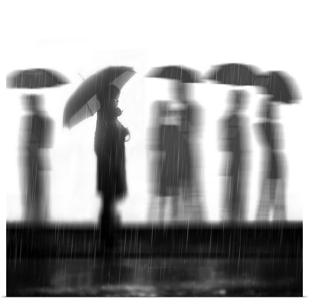 People walking with umbrellas in the rain, with one person in focus.