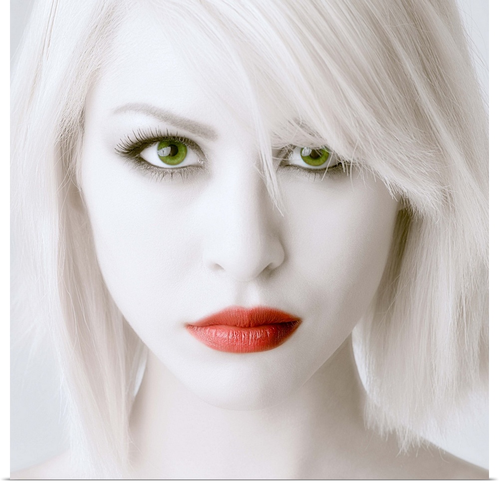 Portrait of a woman with stark white skin and hair, large green eyes, and red lips.