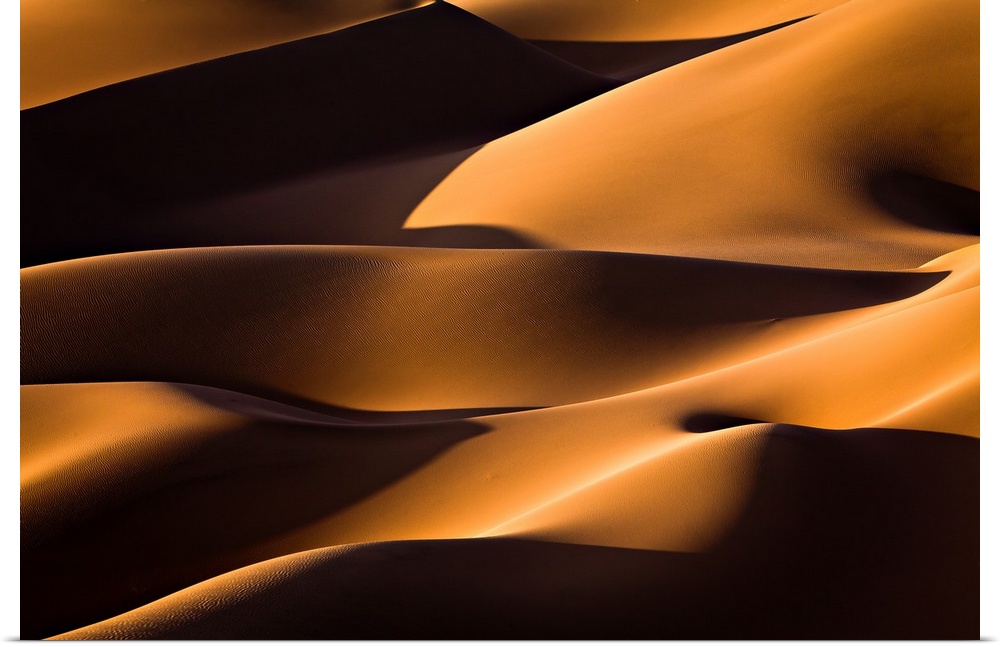 Dark shadows on the giant sand dunes of the Iranian desert.