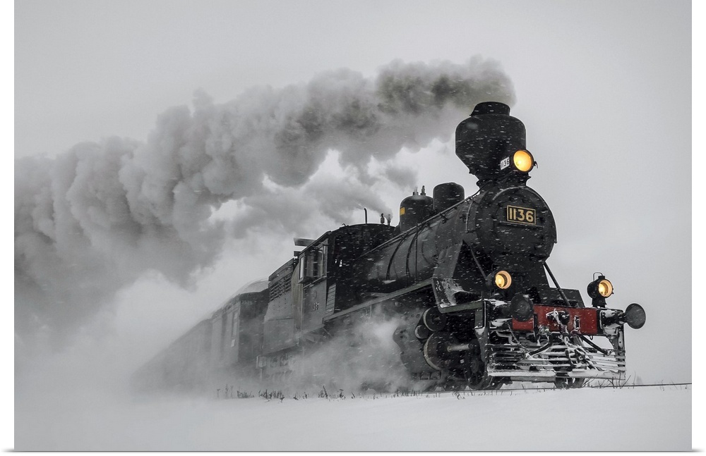 A powerful locomotive races through the snowy landscape in the desert, leaving billowing steam behind.