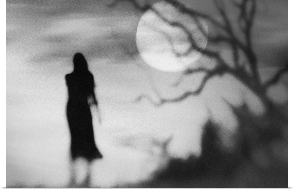 Eerie conceptual photograph of a silhouetted woman against a background with a full moon.