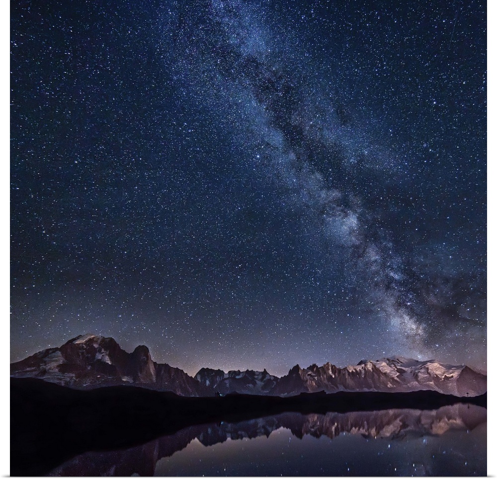 A beautiful view of the Milky Way galaxy and the stars above a mountain range, with a lake reflecting the sky.