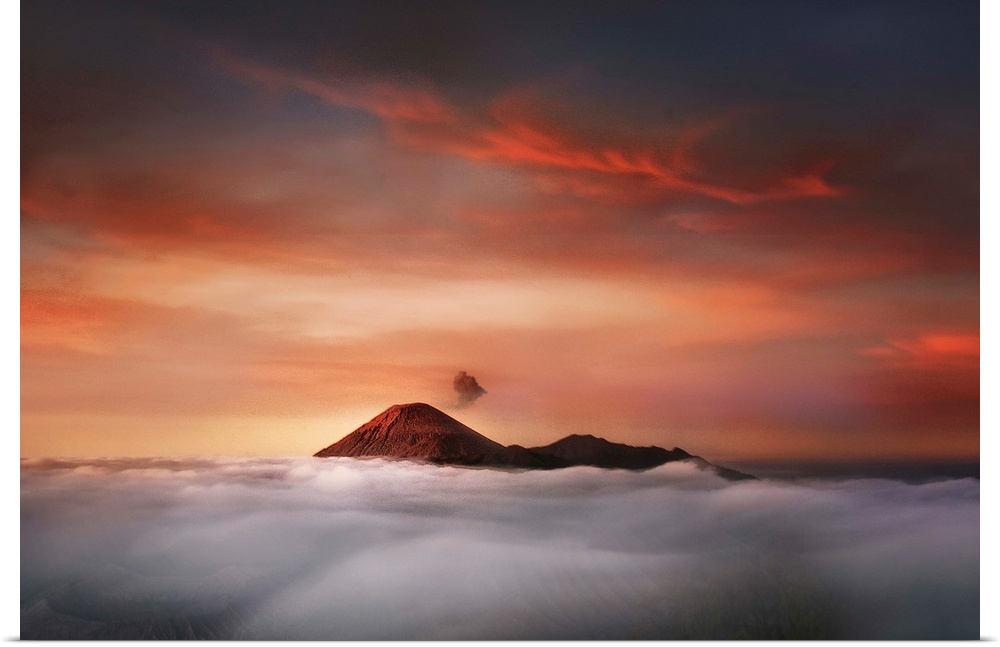 The peaks of Mahameru in Indonesia at sunset, visible over the clouds.