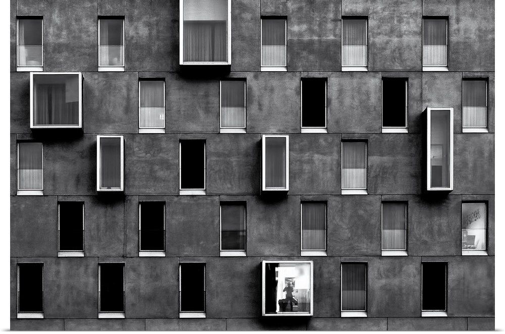 Facade of an apartment building with windows forming a repeating pattern.