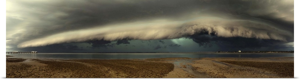 Panoramic image of a beach with a thick wall of stormclouds approaching.