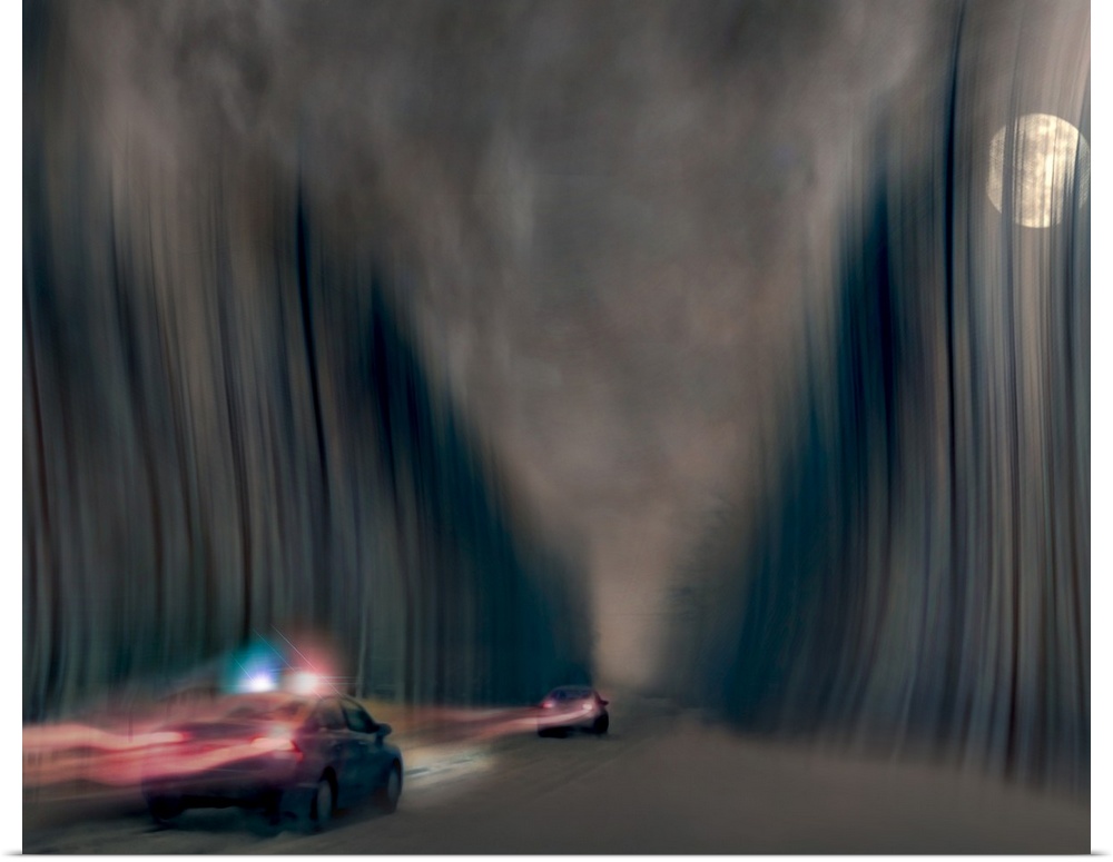 Blurred motion image of a police car chasing a speeding vehicle.