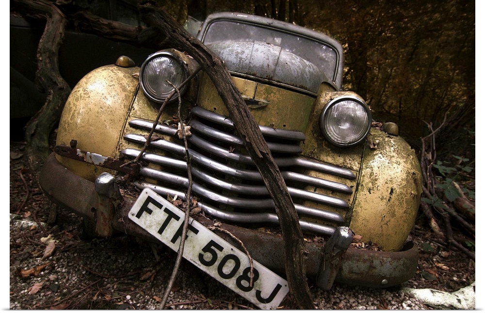 An abandoned old car left alone in the woods.