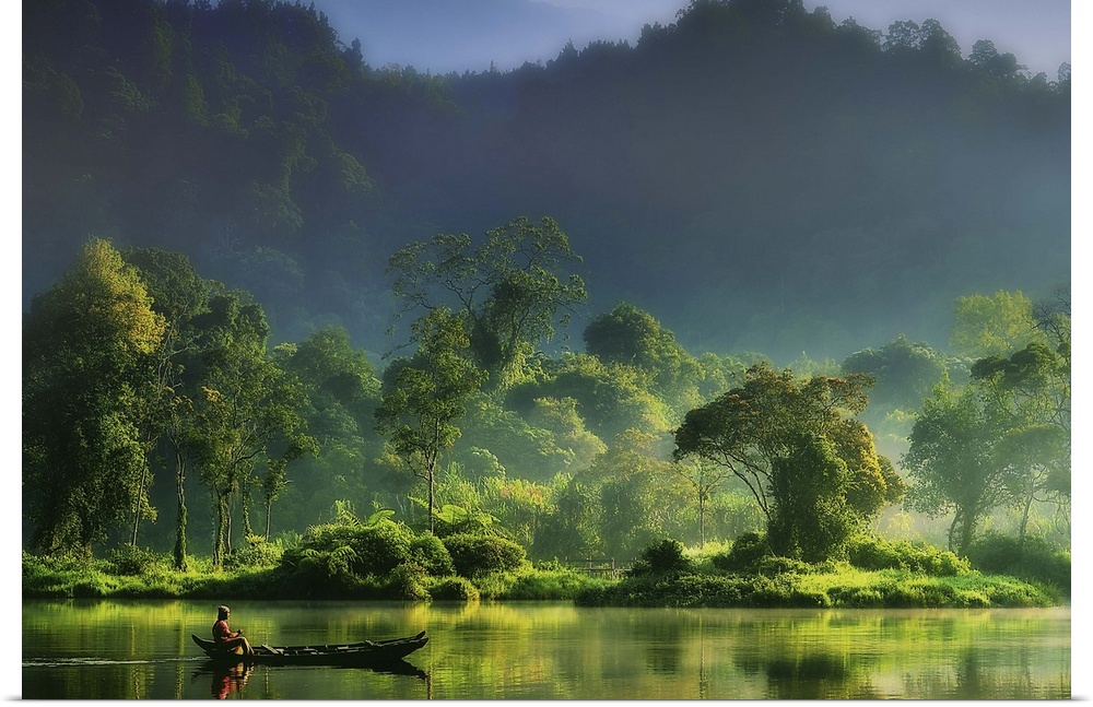 A figure on a boat in the middle of a river in the lush green Indonesian jungle.
