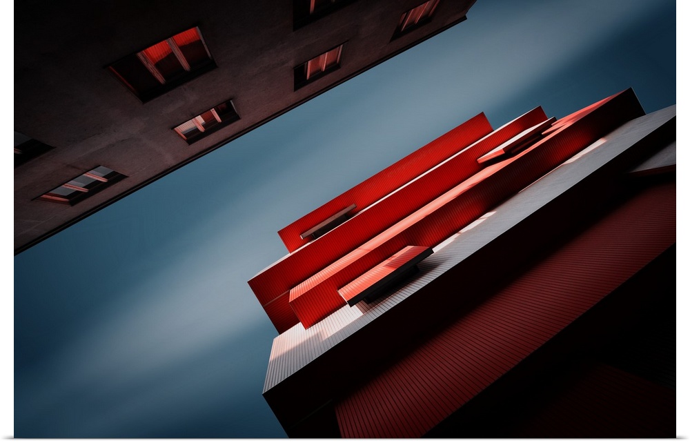 View from below of two buildings with interesting red architecture.