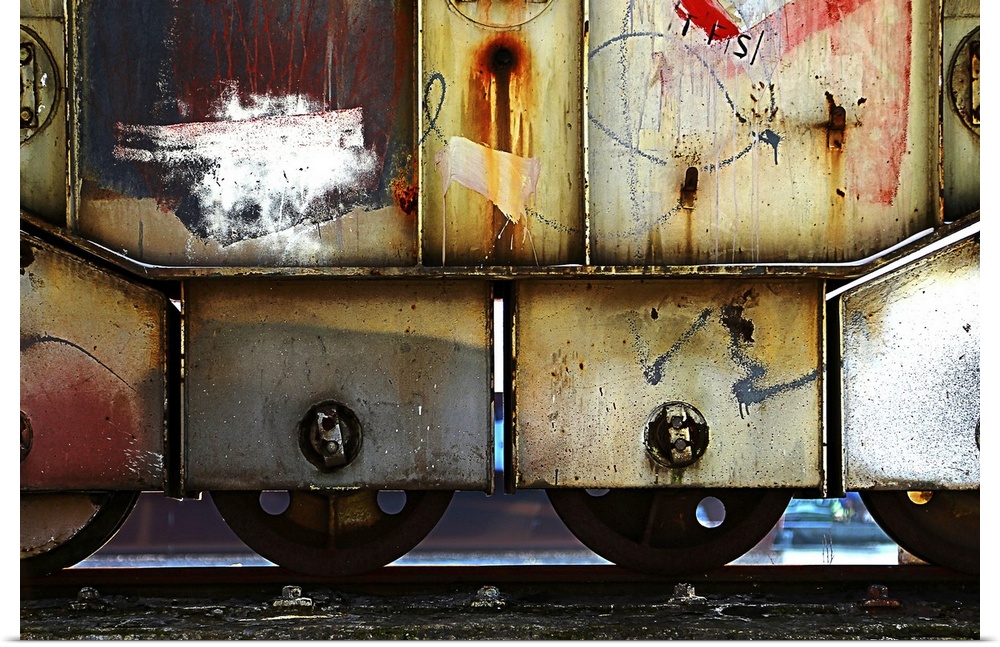 A fine art photograph of a graffiti'd train car sitting on the rails.