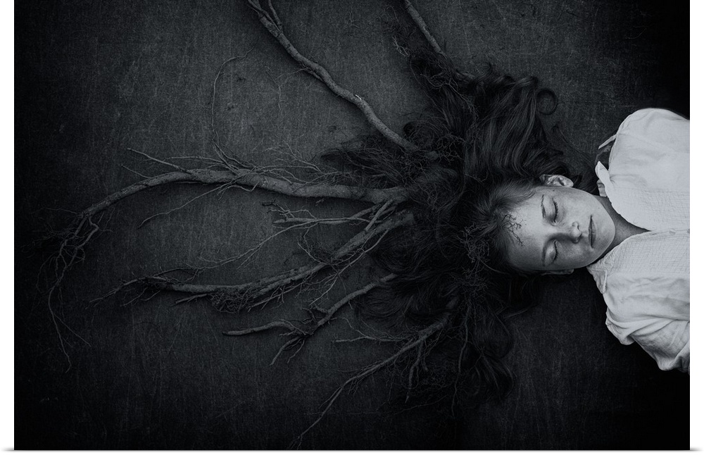 Conceptual image of a young girl laying on the ground, with her hair transforming into roots.