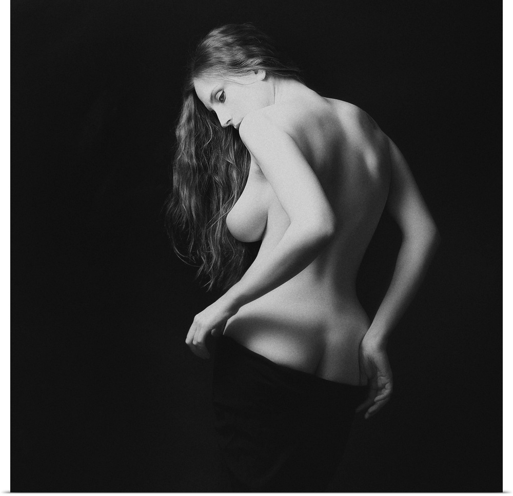 A black and white portrait of nude woman from behind partially exposed.