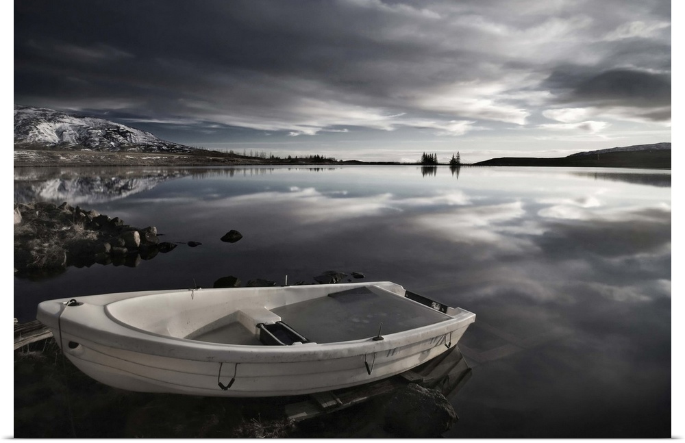 A small boat on the edge of a still lake, Iceland.