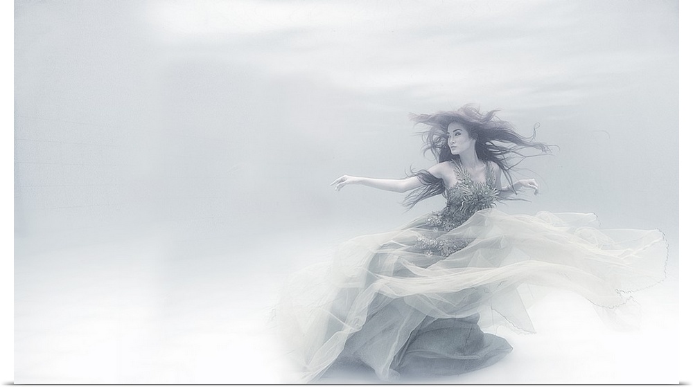 Underwater portrait of a woman in a flowing dress, in soft white light.