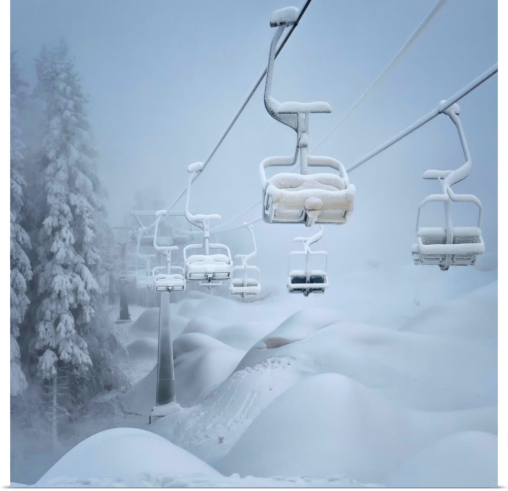 A ski lift and surrounding landscape covered in snow.