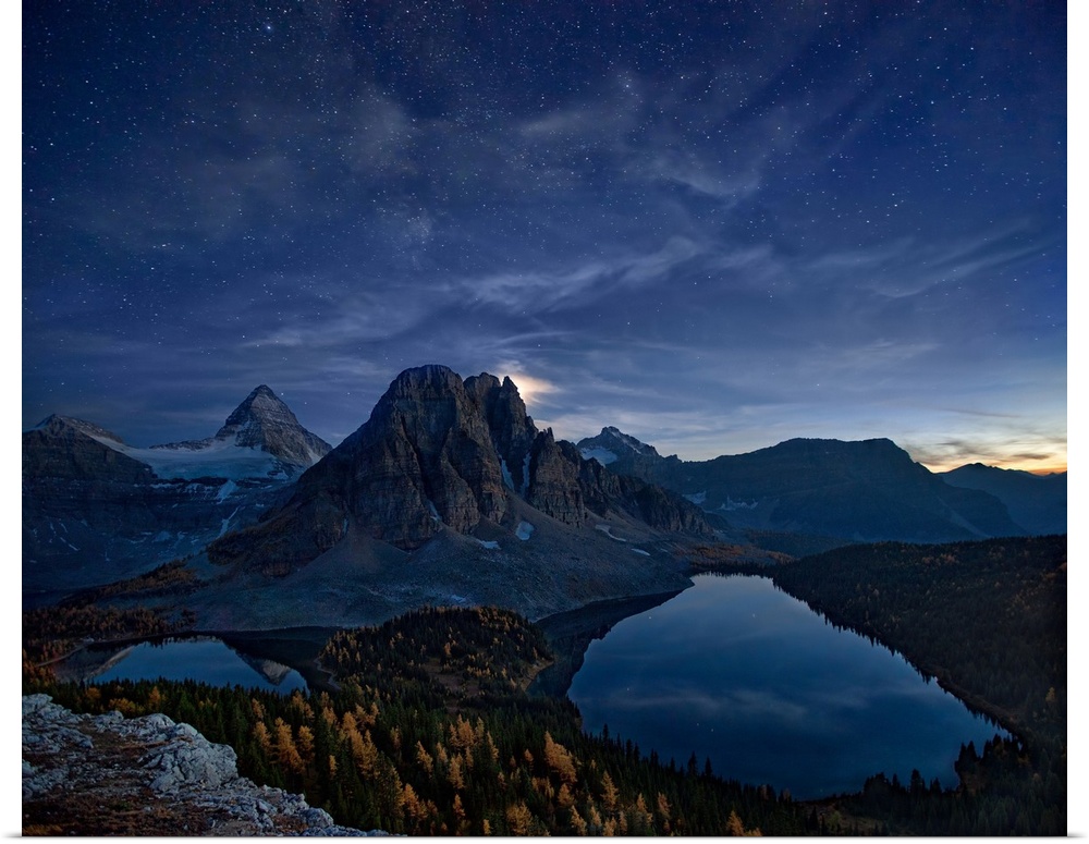 Mount Assiniboine in the Canadian Rockies at night, under a starry sky.