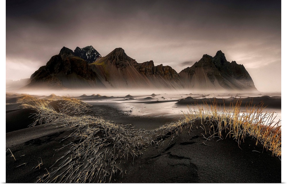 A jagged mountain range in a black sand valley in Iceland.